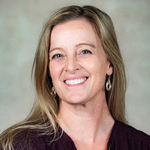 Woman smiling, promoting ketamine-assisted psychotherapy careers.